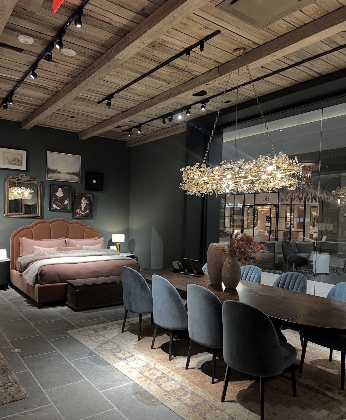 Furniture showroom with a dining table, upholstered chairs, and a bed