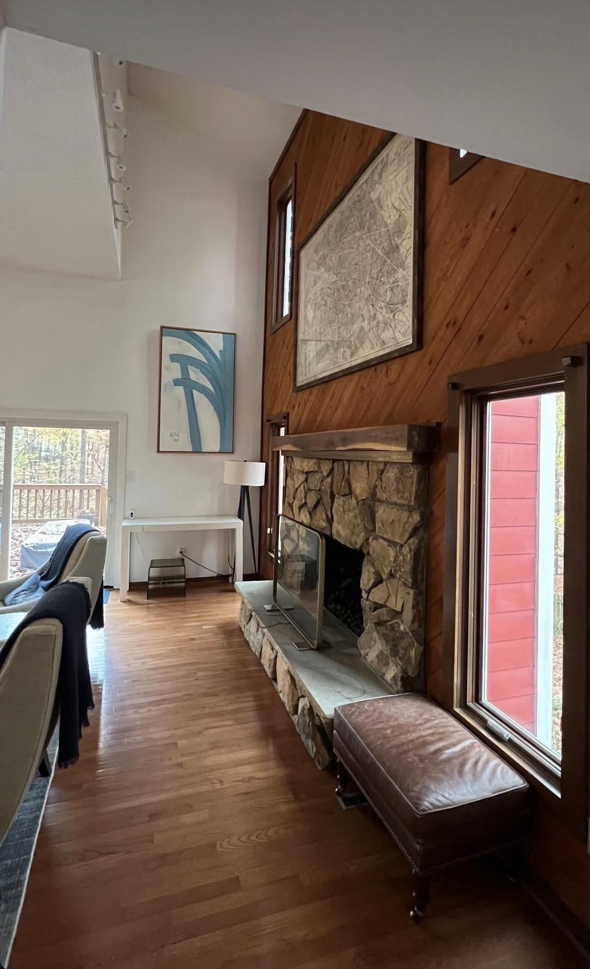 Living room with a stone fireplace, artwork, and carefully arranged furniture